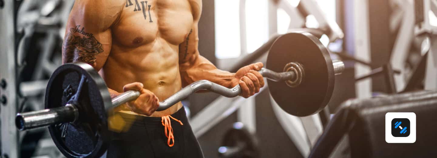 Man lifting a barbell in a hotel gym, using Alpha Progression, emphasizing how travelers can stay fit and active on the road.