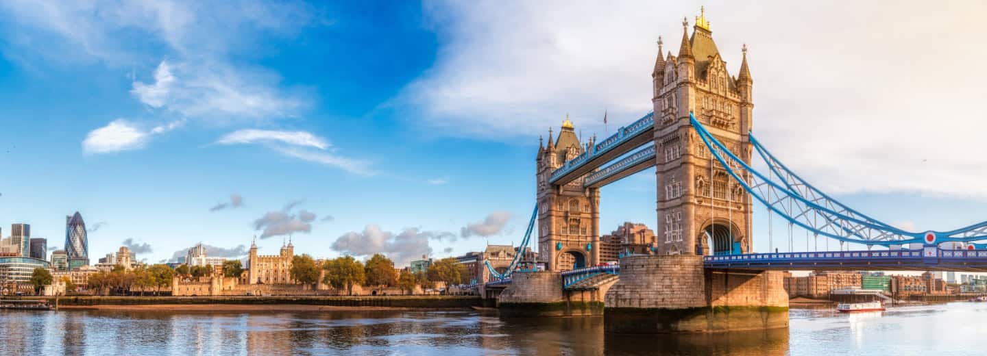 Tower Bridge spans the Thames in London, with cityscapes and a blue sky nearby—perfect for a scenic run while staying fit abroad.