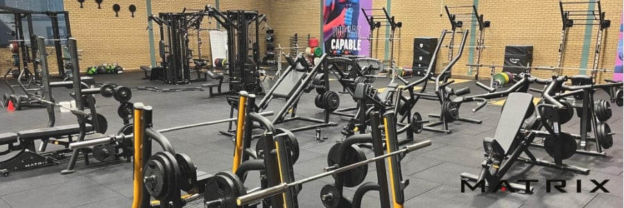 Maintain your fitness routine while traveling in this spacious gym featuring weight machines, benches, and equipment on rubber flooring.