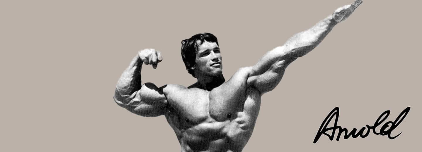Arnold Schwarzenegger poses with one arm flexed and the other pointed up; "Arnold" is signed in black, inspiring travelers to stay fit.